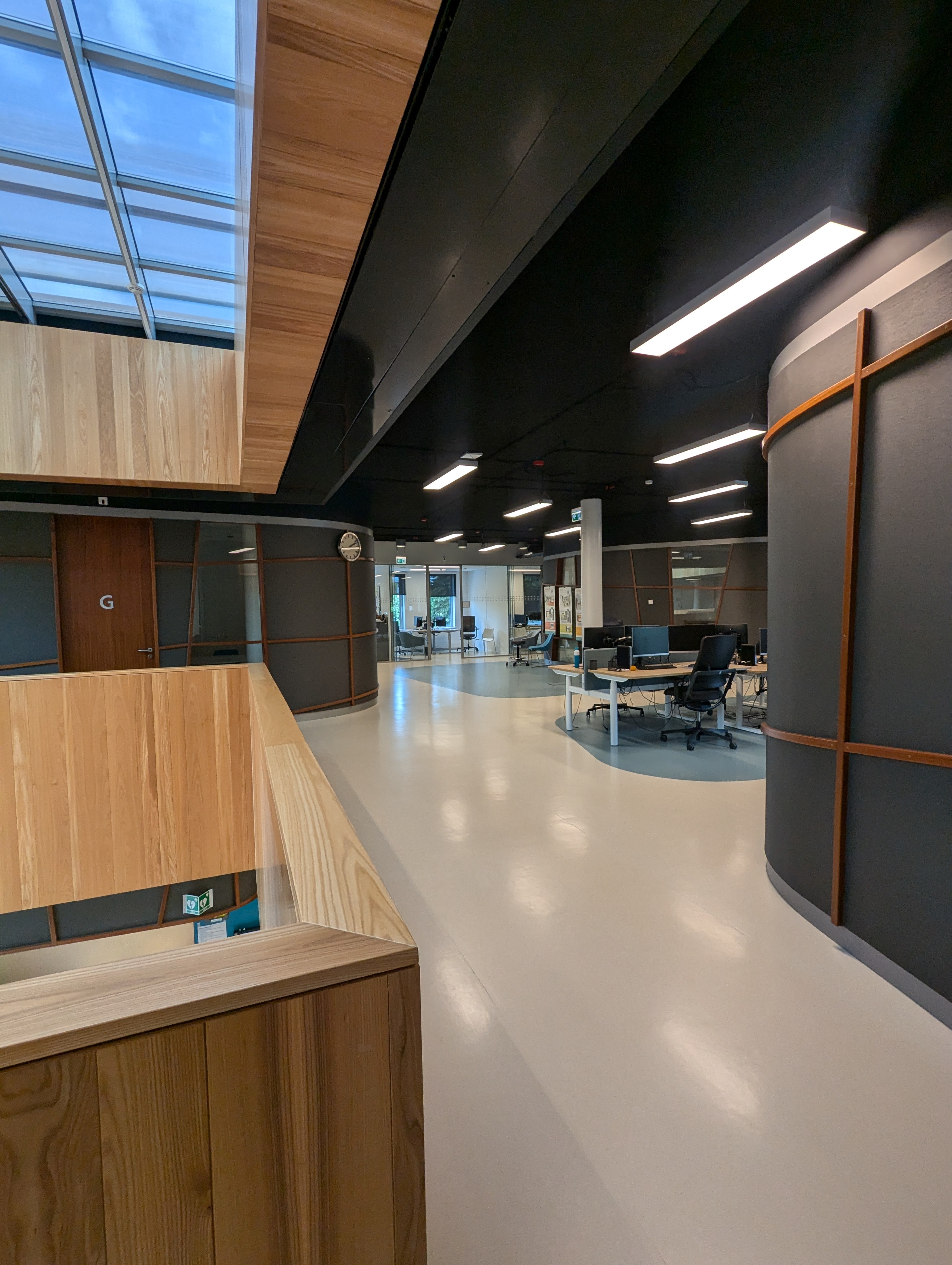 Inside Dianet's dialysis facility. There is a corridor through the area which is has dark painted walls, with wood accents and a light beige floor