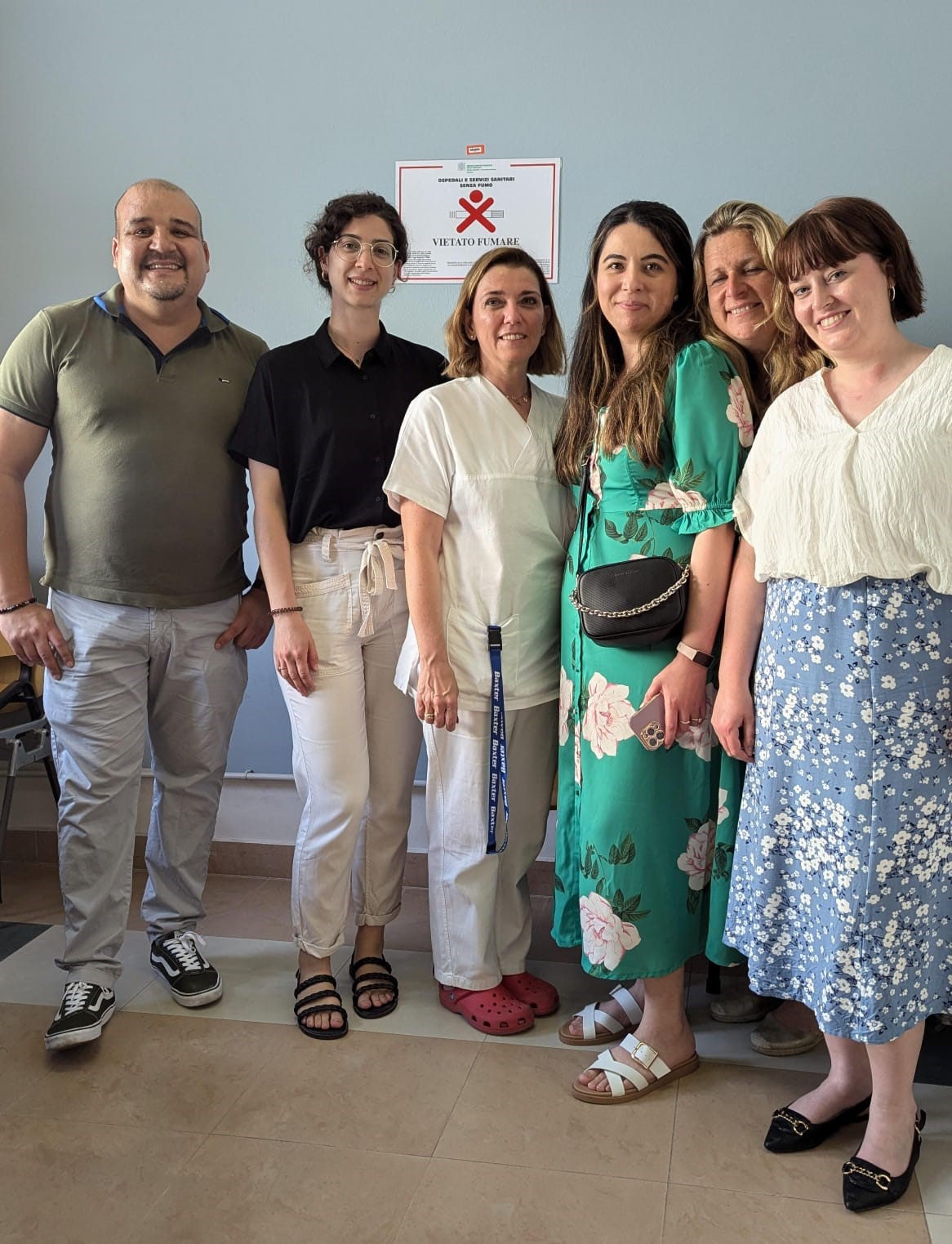 A group pose for a photo in a meeting room. The group consist of Cesar and Sofia from ICONS with Dr.Ligabue, Aycan, Lucy and Hattie. All are smiling